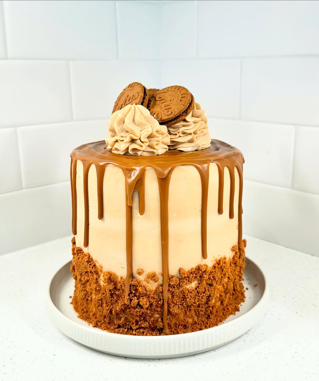 A frosted layer cake with caramel drip at Baking Therapy Cafe