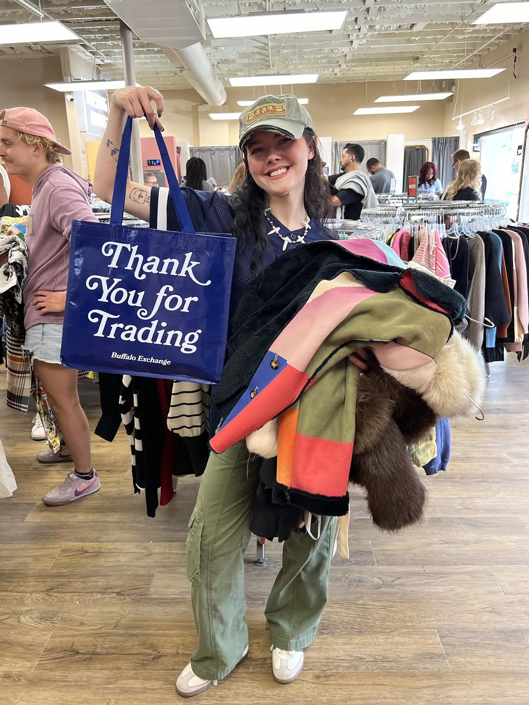 A shopper with an armful of traded clothes and a Buffalo Exchange tote at the East Nashville grand opening