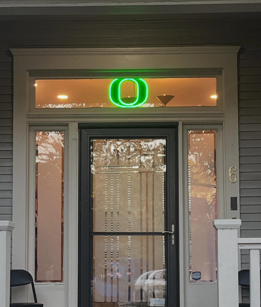 The front door of Nashville Running Company's new shop at 6 S 14th Street, with the green O lit in the window above the door